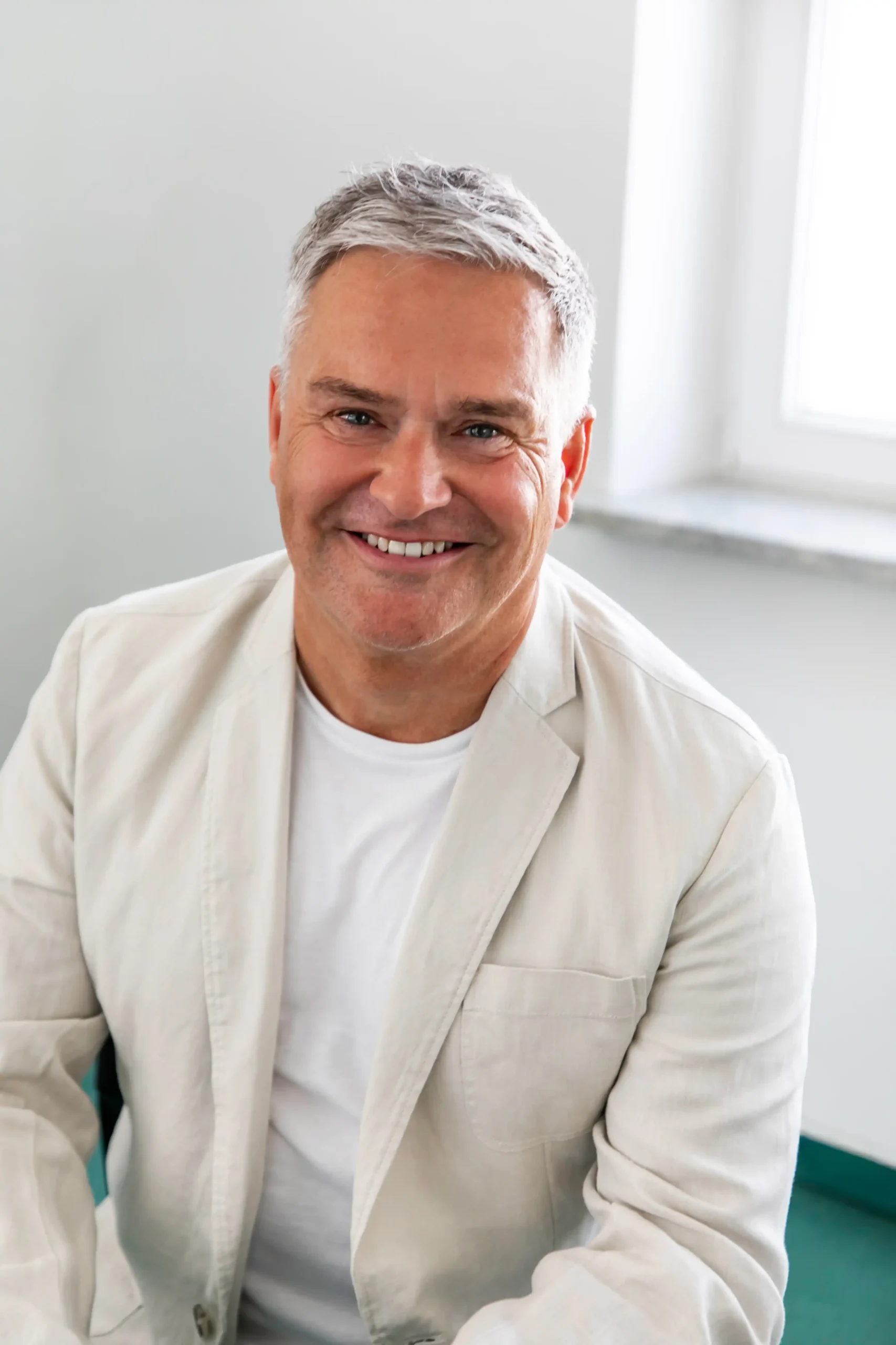 Porträt von Dr. med. Andreas Brunkow, Facharzt für Plastische und Ästhetische Chirurgie. Er lächelt freundlich und zugewandt in die Kamera.